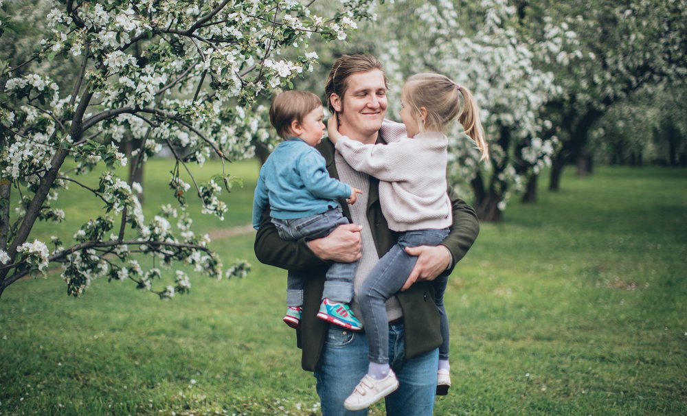 Vater mit zwei Kindern im Arm