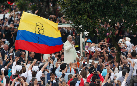 Papst Franziskus fährt an einer großen kolumbianischen Flagge vorbei, auf der ein Rosenkranz aufgemalt wurde, und begrüßt die Menschen, als er am 7. September 2017 im Papamobil den Simon Bolivar Park in Bogota erreicht.