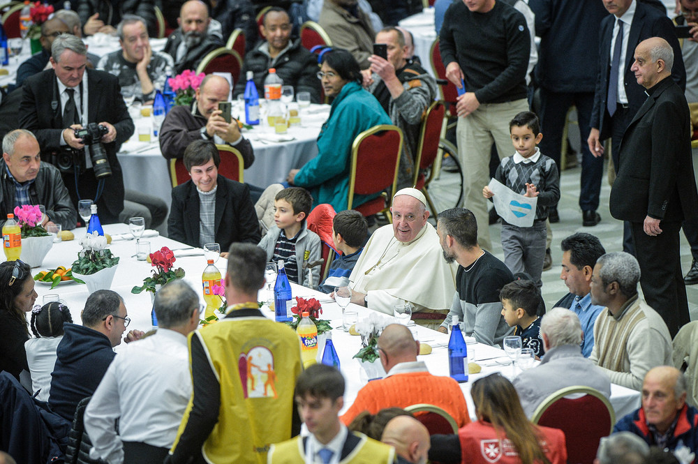 Papst Franziskus beim Mittagessen mit Bedürftigen / Copyright 2022, KNA GmbH, www.kna.de, All Rights Reserved, Stefano Carofei Papst Franziskus sitzt an einem Tisch bei einem Mittagessen zum Welttag der Armen am 13. November 2022 in der Synodenaula im Vatikan.