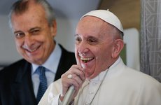 Papstreise nach Mexiko mit einem Zwischenstopp in Kuba. Bild: Papst Franziskus spricht am 12. Februar 2016 auf dem Flug nach Havanna durch ein Mikrofon. Neben ihm steht der päpstliche Reiseplaner Alberto Gasparri.